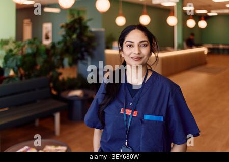 Porträt einer selbstbewussten Ärztin, die in der Krankenhauslounge posiert Stockfoto