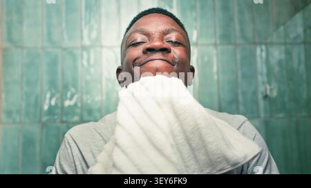 Lächelnder Mann Trocknendes Gesicht Mit Handtuch Im Badezimmer Zeigt Pflege, Selbstvertrauen Und Frische Hygiene Stockfoto