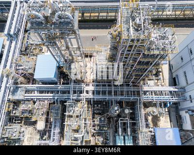 Hochwinkeldrohnenaufnahme komplexer Rohrleitungen und Stahlkonstruktionen in einem massiven petrochemischen Werk und Industriekomplex. Stockfoto