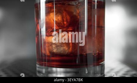 Nahaufnahme eines bernsteinfarbenen alkoholischen Getränks mit Eiswürfeln in einem Glas, das eine kühle Erfrischung an einem heißen Tag bietet Stockfoto