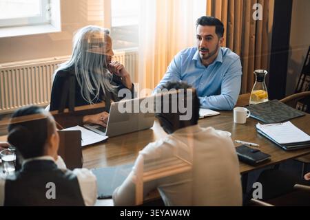 Geschäftsmitarbeiter, die im Besprechungsraum geschäftlich diskutieren Stockfoto