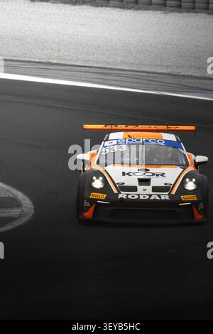 MISANO, ITALIEN – 10. MAI 2026: Künstlerisches Schwarz-weiß-Actionfoto mit einem Porsche GT3 Cup Rennwagen mit leuchtenden orangefarbenen Aufklebern, die i hervorgehoben sind Stockfoto