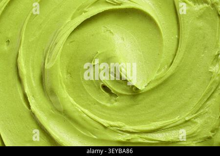Nahaufnahme einer glatten Pistaziencreme-Textur mit cremigen Wirbeln und sattem Grün. Abstrakter Lebensmittelhintergrund ideal für gesunde Ernährung, Snack c Stockfoto