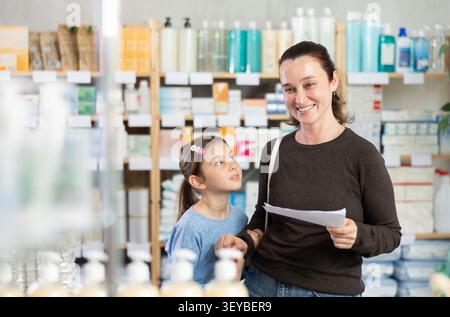 Die Frau hält ein ärztliches Rezept in der Nähe eines Kindes Stockfoto