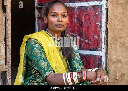 Junge Frau in einem Sari, die in einem Eingang in Jaisalmer, Indien, sitzt Stockfoto