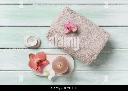 Wellnessbereich mit Handtuch, Kerzen und Orchideenblumen Stockfoto