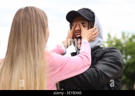 Frau bemannt die Augen draußen in spielerischer Geste Stockfoto