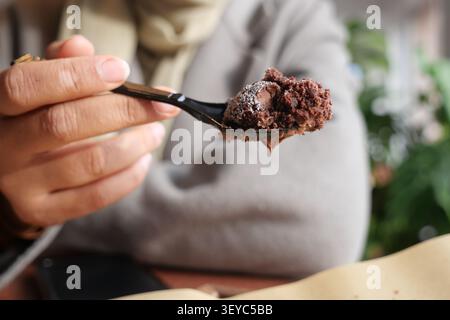 Genießen Sie das Dessert mit einem Löffel in gemütlicher Umgebung Stockfoto