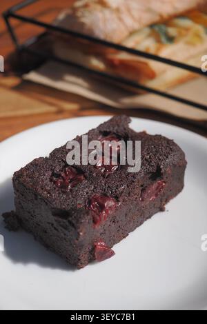 Schokoladenkuchen mit Kirschen auf einem weißen Teller Stockfoto