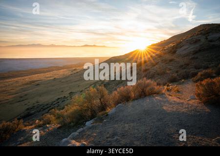 Wunderschöner Sonneneffekt mit scharfen Sonnenstrahlen, die über einen felsigen Hügel auf Antelope Island, Utah, brechen. Stockfoto