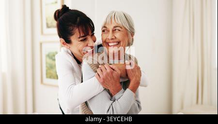 Umarmen, lachen und Frau mit Senioreneltern zu Hause für Bindungen, Beziehungen oder Besuch. Sorgfalt, lustig und lächelnd der erwachsenen Tochter, die die Mutter umschließt Stockfoto
