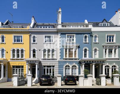 London, Großbritannien - 25. Mai 2026: Reihe eleganter pastellfarbener Stadthäuser in einer ruhigen Stadtstraße von Elgin Crescent, Notting Hill, mit geparkten Autos, GREE Stockfoto