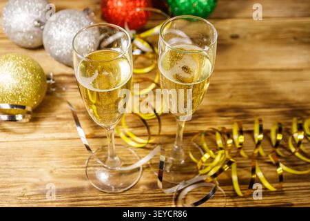 Zwei Gläser Champagner und festliche Weihnachtsdekoration auf Holztisch. Weihnachten und Neujahrsfeier Stockfoto
