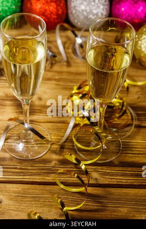 Zwei Gläser Champagner und festliche Weihnachtsdekoration auf Holztisch. Weihnachten und Neujahrsfeier Stockfoto