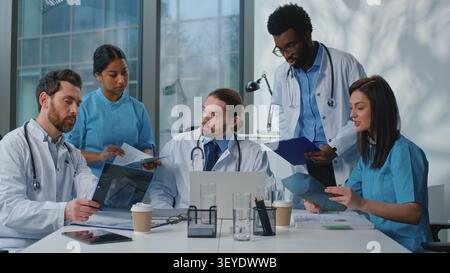 Das medizinische Team kooperiert in der Klinik. Kaukasischer Arzt Chef Führer selbstbewusster Vortrag führende Medizin Konferenz mit multiethnischen fünf Stockfoto