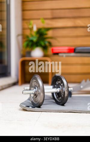 Verstellbare Hanteln auf dem Boden in einem modernen Heimfitnessstudio Stockfoto