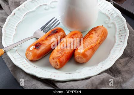 Gegrillte Premium-Schweinefleisch-Würstchen im taiwanesischen Stil auf Teller mit Holzbrett Stockfoto
