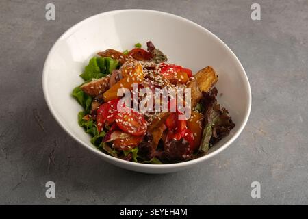 Bunter gerösteter Gemüsesalat in weißer Schüssel mit Salat, Tomaten, Paprika, Sesam Stockfoto