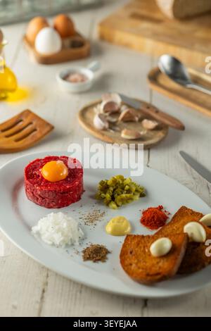 Steak Tartar, Vorspeise aus rohem Rindfleisch, verschiedene Gewürze und geröstetes Brot Stockfoto