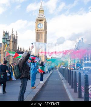 Demonstranten halten Leuchtfackeln auf der Westminster Bridge, um den isländischen Frauenstreik von 1975 während einer Pro-Palästina-Demonstration im Oktober 2024 zu gedenken Stockfoto