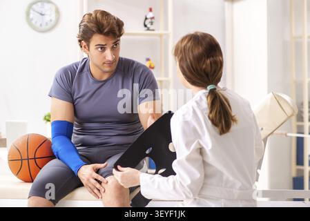 Stattliche Basketballspieler besuchen Ärztin traumatologist Stockfoto
