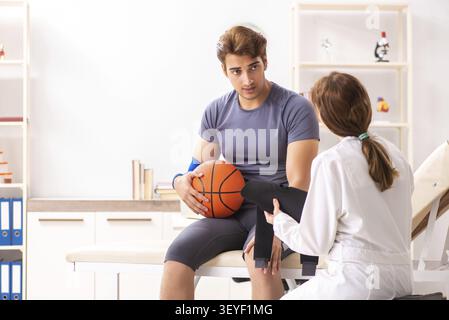 Stattliche Basketballspieler besuchen Ärztin traumatologist Stockfoto