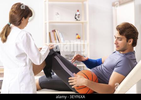 Stattliche Basketballspieler besuchen Ärztin traumatologist Stockfoto