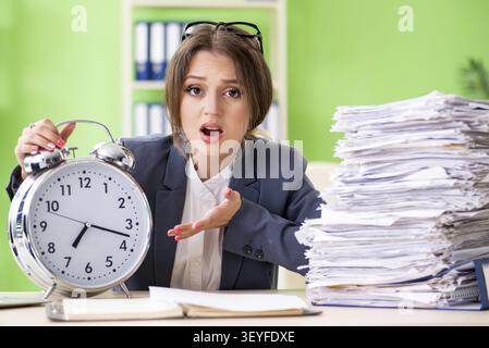 Junge weibliche Mitarbeiter sehr beschäftigt mit laufenden Schreibarbeit in der Zeit Management Konzept Stockfoto
