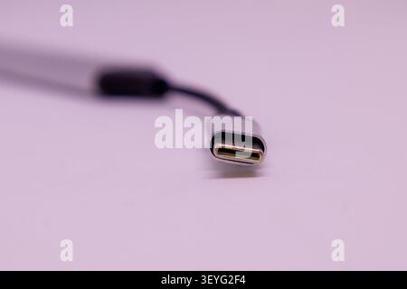 Ein USB-Anschluss Typ C ist in der Nahaufnahme dargestellt. Das Kabel hat einen einfachen Hintergrund, der die Form und das Design des Steckverbinders unterstreicht. Stockfoto