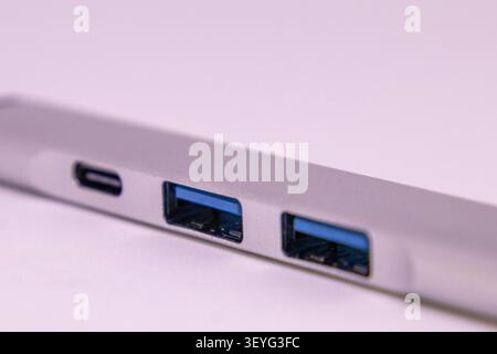 Ein USB-Hub befindet sich auf einer glatten Oberfläche. Der Hub verfügt über mehrere Anschlüsse einschließlich USB A und USB C. das Design des Hubs ist einfach und modern. Stockfoto