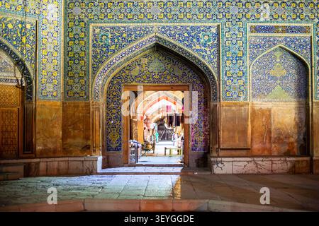 Frontalaufnahme eines bogenförmigen Portals mit atemberaubenden blauen und gelben Mosaikfliesen aus der Safawiden-Ära. Die Öffnung zeigt einen hellen, perspektivischen Blick Stockfoto
