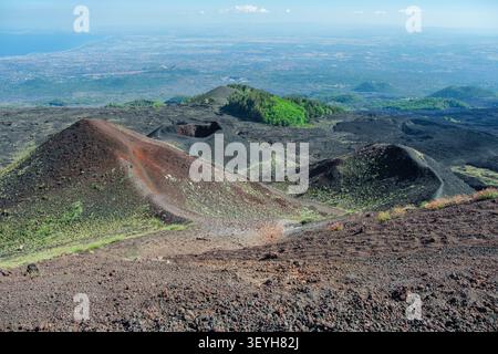 Vulkanische Schlackenzapfen und Krater auf dem Ätna überblicken Catania und Siziliens trübe Küste Stockfoto