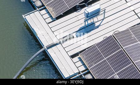Luftaufnahme von schwimmenden Solarpaneelen, die auf Wasser mit elektrischen Kabeln und Infrastruktur in Zwolle, Overijssel, Niederlande, installiert sind. Stockfoto