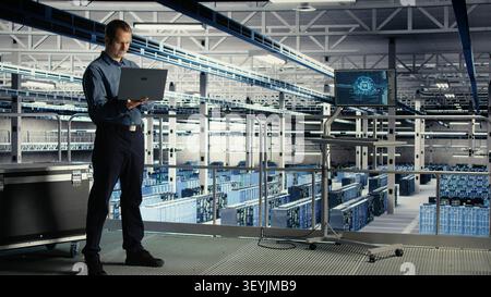 Der Administrator eines Rechenzentrums verwendet einen Laptop, um ein KI-Dashboard zu überprüfen und dabei mit KI-Technologie und Hochleistungssystemen zu arbeiten. Stockfoto