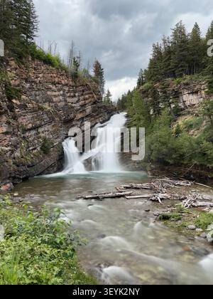 Wasser stürzt über uralten geschichtetem Fels an den Cameron Falls, einem beliebten Ziel für kurze Wanderungen im Waterton Lakes Nationalpark, Alberta, Kanada. Stockfoto