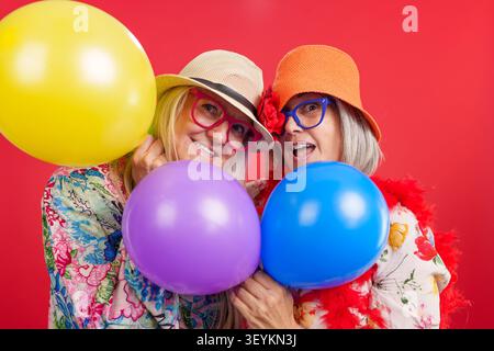 Seniorinnen feiern Freundschaft mit bunten Ballons Stockfoto