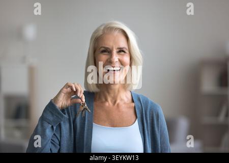 Glückliche lachende ältere Erwachsene weibliche Blick auf die Kamera, die Schlüssel hält Stockfoto