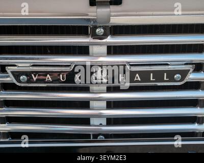 Eine detaillierte Nahaufnahme des klassischen Emblems aus glänzendem Chrom und des Logos auf dem Kühlergrill eines Vauxhall Viva-Automobils aus dem Jahr 1965 Stockfoto