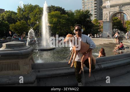 New York, Usa. Juli 2026. Eine Person trägt ihren Hund aus einem Brunnen im Washington Square Park, Manhattan, New York City. (Foto: Jimin Kim/SOPA Images/SIPA USA) Credit: SIPA USA/Alamy Live News Stockfoto
