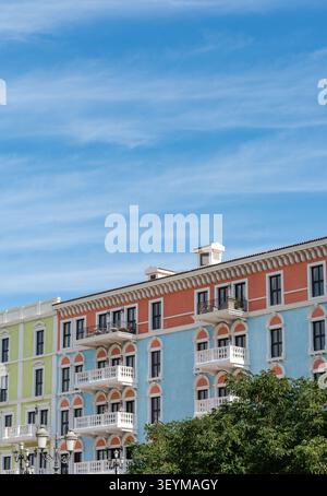 Doha, Katar - 28. Januar 2026: Eine vertikale, flache Aufnahme farbenfroher Wohnhäuser im venezianischen Stil unter einem hellblauen Himmel mit viel Kopierraum. Stockfoto