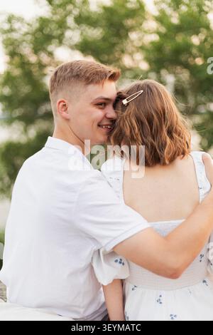Ein Mann und eine Frau teilen einen zärtlichen Moment im Freien, ihre Verbindung wird in ihrer Umarmung und ihren fröhlichen Ausdrücken deutlich Stockfoto