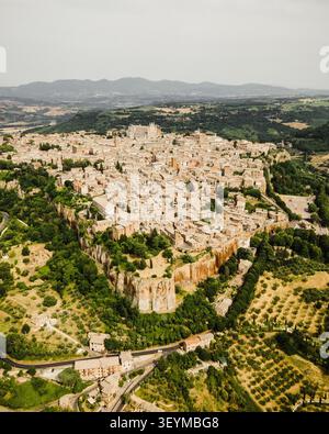 Blick aus der Vogelperspektive auf die historische Bergstadt Orvieto mit ihrer berühmten Kathedrale, dichten Steindächern und alten Befestigungsanlagen auf einem wolkenkessel Stockfoto