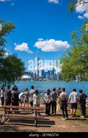 Toronto, Ontario, Kanada - 20. Juni 2026: Eine große Gruppe von Menschen steht am Ufer, um Fotos von der Skyline von Toronto zu machen Stockfoto