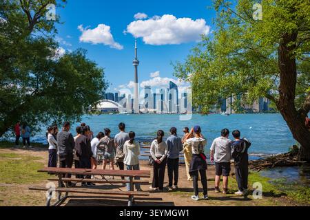 Toronto, Ontario, Kanada - 20. Juni 2026: Eine große Gruppe von Menschen steht am Ufer, um Fotos von der Skyline von Toronto zu machen Stockfoto