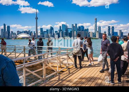 Toronto, Ontario, Kanada - 20. Juni 2026: Eine große Gruppe von Menschen steht am Ufer, um Fotos von der Skyline von Toronto zu machen Stockfoto