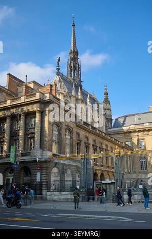 Seitenansicht der Sainte Chapelle und des Palais de Justice in Paris, Frankreich, mit Menschen, die in der Nähe der goldenen Tore und des gotischen Turms laufen. Paris, Frankreich - Oktob Stockfoto