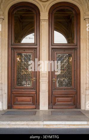 Diese großen Doppeltüren mit komplizierten Metallgittern dienen als eleganter Eingang zu einem historischen Gebäude und laden Gäste ein, sich für verschiedene Gäste zu betreten Stockfoto