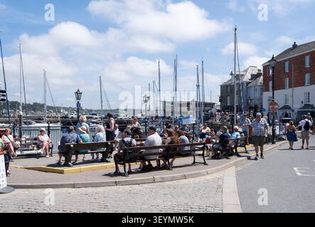 Außerhalb der Saison laufen im Juni Menschenmassen durch den Hafen von Padstow, Cornwall, England. Stockfoto