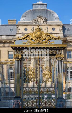 Verzierte goldene Tore und Fassade des Justizpalais in Paris, Frankreich, mit klassischer Architektur unter klarem blauen Himmel. Stockfoto