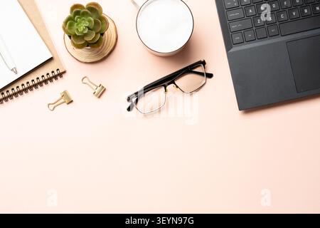 Büroarbeitsplatz mit flachem Hintergrund. Laptop, Notebook, Kaffeetasse und Gläser, Stockfoto